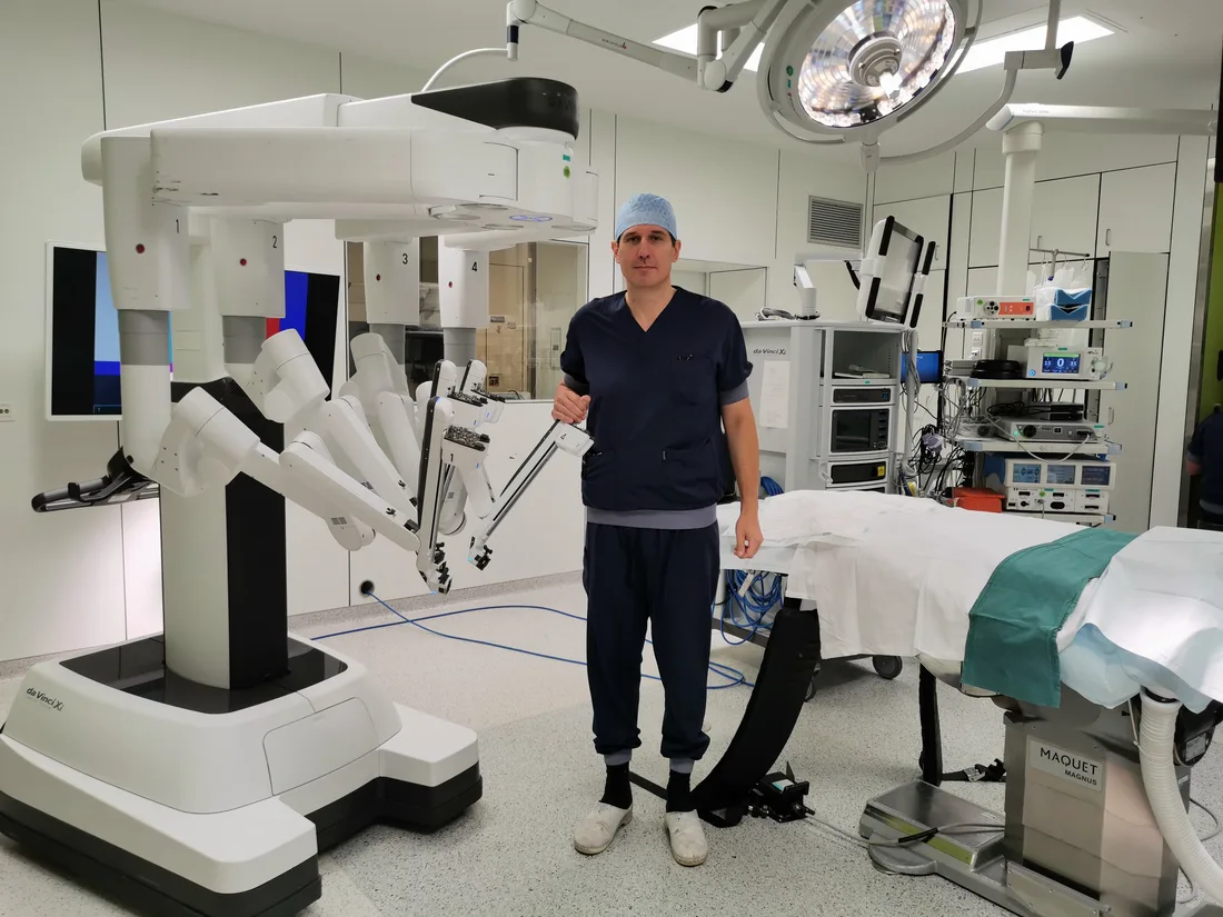 Chirurg dr. Simon van de Vrande naast de da Vinci-operatierobot
